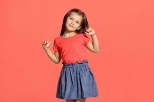 Close-up studio shot of beautiful brunette little girl posing against a blue background. photo