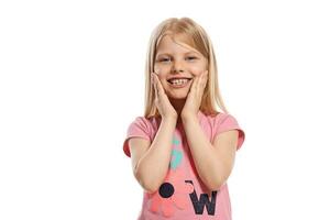 de cerca retrato de un bonito rubia pequeño niño en un rosado camiseta posando aislado en blanco antecedentes. foto