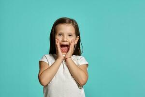 Close-up studio shot of beautiful brunette little girl posing against a blue background. photo