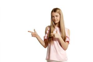 estudio retrato de un hermosa niña rubia adolescente en un rosado camiseta posando aislado en blanco antecedentes. foto