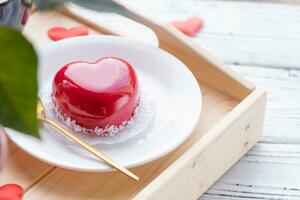 heart shaped glazed valentine cake in bed on wooden tray photo