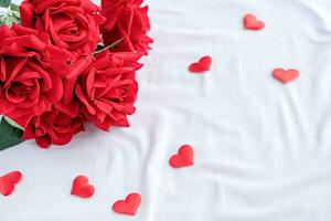 rojo rosas con corazón conformado papel picado en cama foto