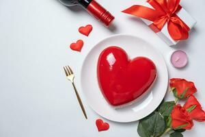 heart shaped glazed valentine cake, gift and champagne on white background photo