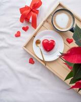 corazón conformado vidriado enamorado pastel en cama en de madera bandeja foto