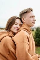 young loving couple wearing trendy colored peach fuzz sweatshirts photo