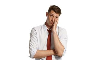 Young man in a classic white shirt and red tie posing isolated on white background. photo