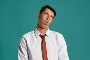 Young man in a classic white shirt and red tie posing over a blue background. photo