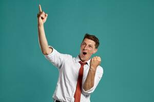 Portrait of a young brunet man posing in a studio against a blue background. photo