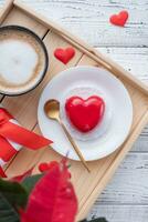 heart shaped glazed valentine cake in bed on wooden tray photo