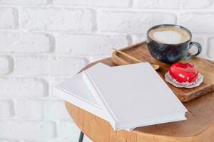 blank books with heart shaped glazed valentine cake in wooden tray photo