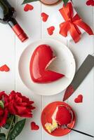 heart shaped glazed valentine cake and flowers on wooden table photo