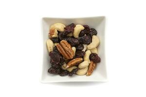 A white bowl with dried fruits and nuts, isolated on white background.Dried fruits are so called because they all have one characteristic in common,they have less than 50percent water. photo