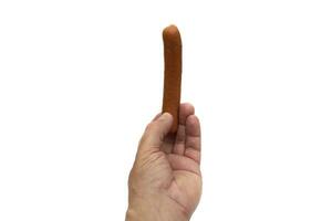 A hand holding a sausage, Bockwurst. Isolated on white background. Bockwurst is a sausage from German cuisine. photo