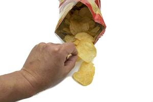 Bag of potato chips, open and front view. With potato chips inside and outside the bag. Isolated on white background. Selective focus. In Western countries, they are a very important part of the snack photo