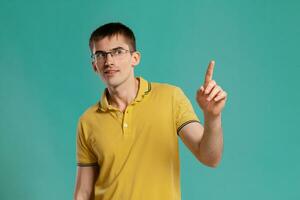 Handsome guy in a yellow casual t-shirt is posing over a blue background. photo