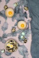 quail eggs in ceramic vases, gray feathers on the table, Easter still life with dietary eggs, diet and antioxidant photo