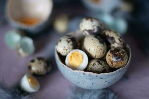 quail eggs in ceramic vases, gray feathers on the table, Easter still life with dietary eggs, diet and antioxidant photo