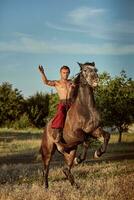 hermoso hombre vaquero montando en un caballo - antecedentes de cielo y arboles foto
