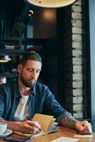 Man hand with pen writing on notebook on a wooden table. photo
