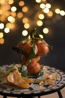 tangerines in a mesh bucket on a table against a background of bright bokeh photo