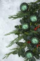 Navidad o nuevo año mesa decoración con abeto sucursales, acebo ramas con bayas foto