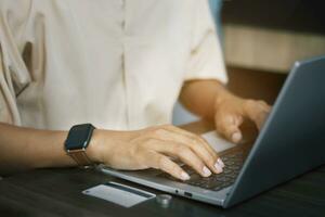 Close-up of male hands using laptop to work at home, finance concept, online shopping with credit card photo