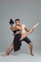 dos atlético moderno ballet bailarines son posando en contra un gris estudio antecedentes. foto