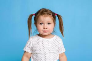 Funny kid in white T-shirt on blue background. Little pretty girl isolated on blue background. Copy space for text. photo