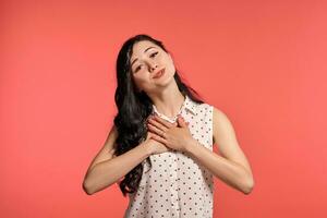 Studio shot of a beautiful girl teenager posing over a pink background. photo