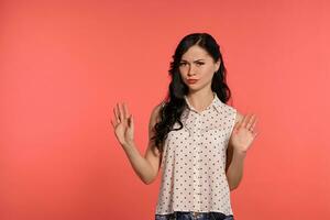 Studio shot of a beautiful girl teenager posing over a pink background. photo