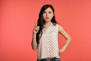 Studio shot of a beautiful girl teenager posing over a pink background. photo