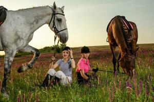 Two woman and two horses outdoor in summer happy sunset together nature photo