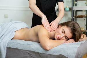 joven mujer consiguiendo un espalda masaje en un spa salón. belleza tratamiento concepto. foto