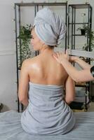 profesional masajista haciendo terapéutico masaje. mujer disfrutando masaje en su hogar. joven mujer consiguiendo relajante cuerpo masaje. foto