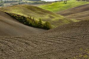 cosechado campos y prados paisaje en toscana, Italia. ondulado país paisaje a otoño puesta de sol. cultivable tierra Listo para el agrícola estación. foto