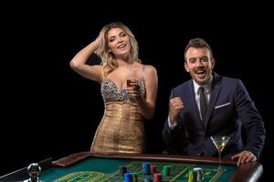 Couple gambling at roulette table in casino photo
