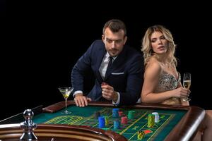 Couple gambling at roulette table in casino photo