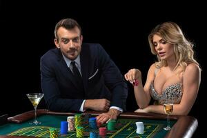 Couple gambling at roulette table in casino photo