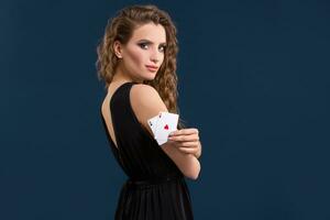 Beautiful brunette holding two aces as a sign for poker game, gambling and casino photo