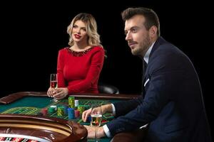 A beautiful young woman and a man are sitting at a roulette table. Casino. photo