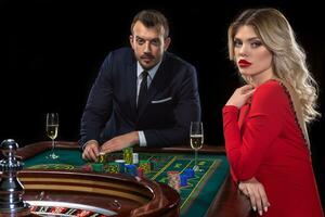 A beautiful young woman and a man are sitting at a roulette table. Casino. photo