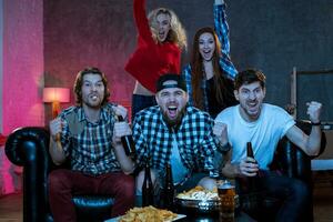 Group of friends watching TV match at home photo