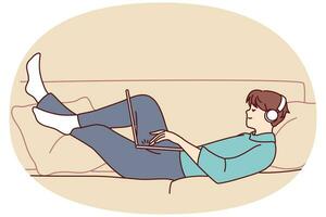 Happy man lying on couch wear headphones work on laptop. Smiling guy relax on sofa at home listen to music in earphones using computer. Vector illustration.