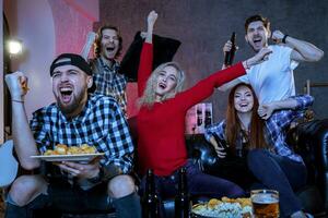 Friends watching a football match and drinking beer. photo