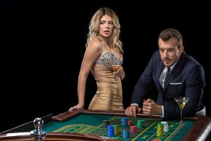 Couple gambling at roulette table in casino photo