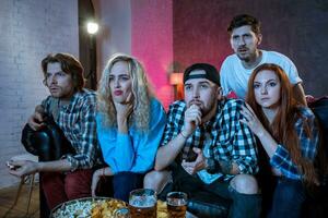 Group of friends watching TV match at home photo