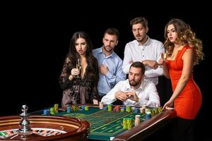 Group of young people looking excited at spinning roulette photo