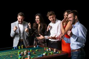 Group of young people looking excited at spinning roulette photo