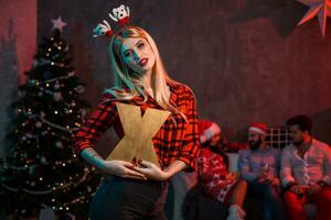 Christmas, x-mas, New year, winter, happiness concept - smiling woman in santa helper hat with a wooden letter X. photo