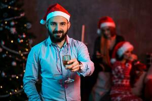Christmas, x-mas, New year, winter, happiness concept - smiling man in santa helper hat with a glass of champagne photo